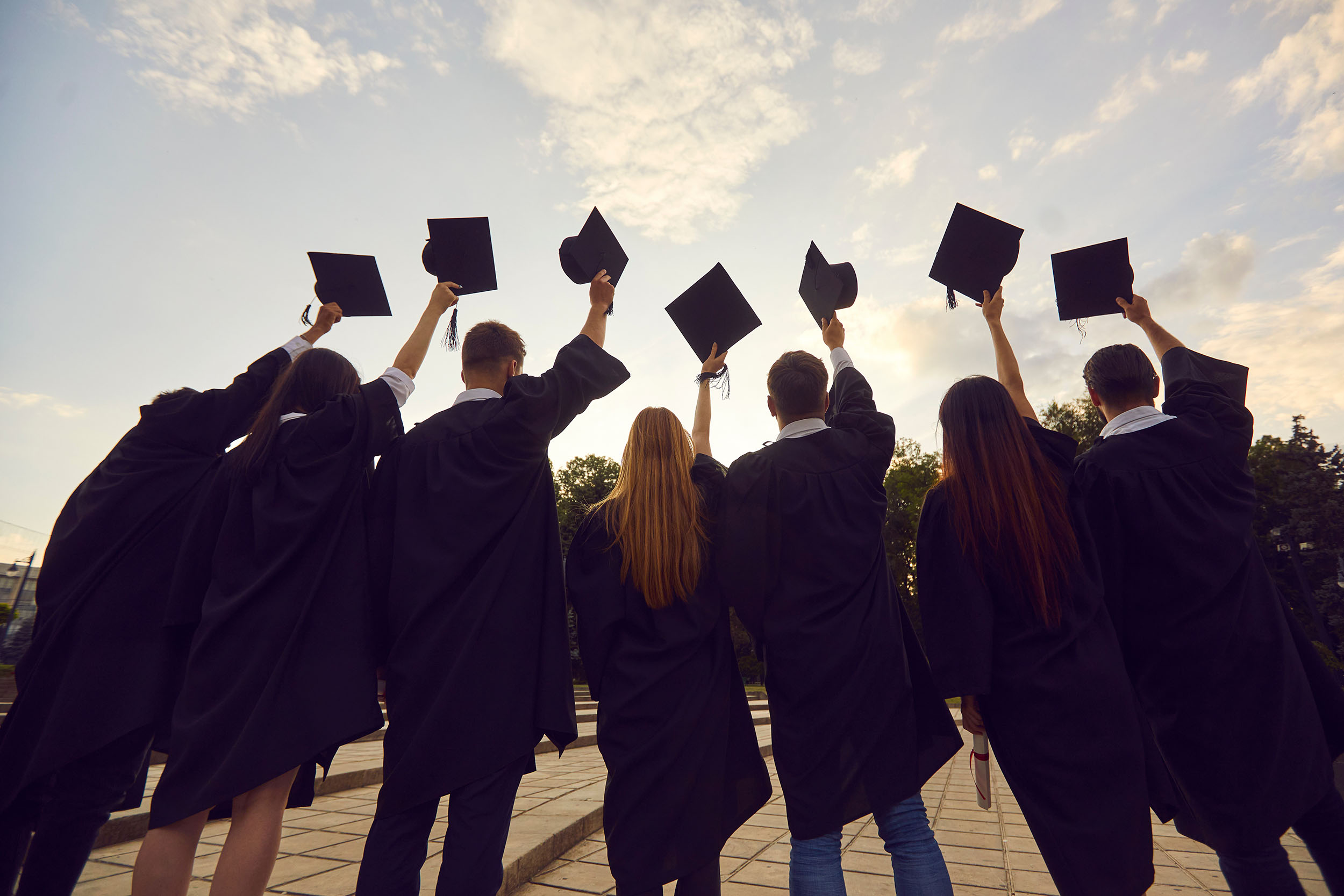 Students in graduating robes with hats held high - Helen and Harvey Pell Fund for Graduating High School Students